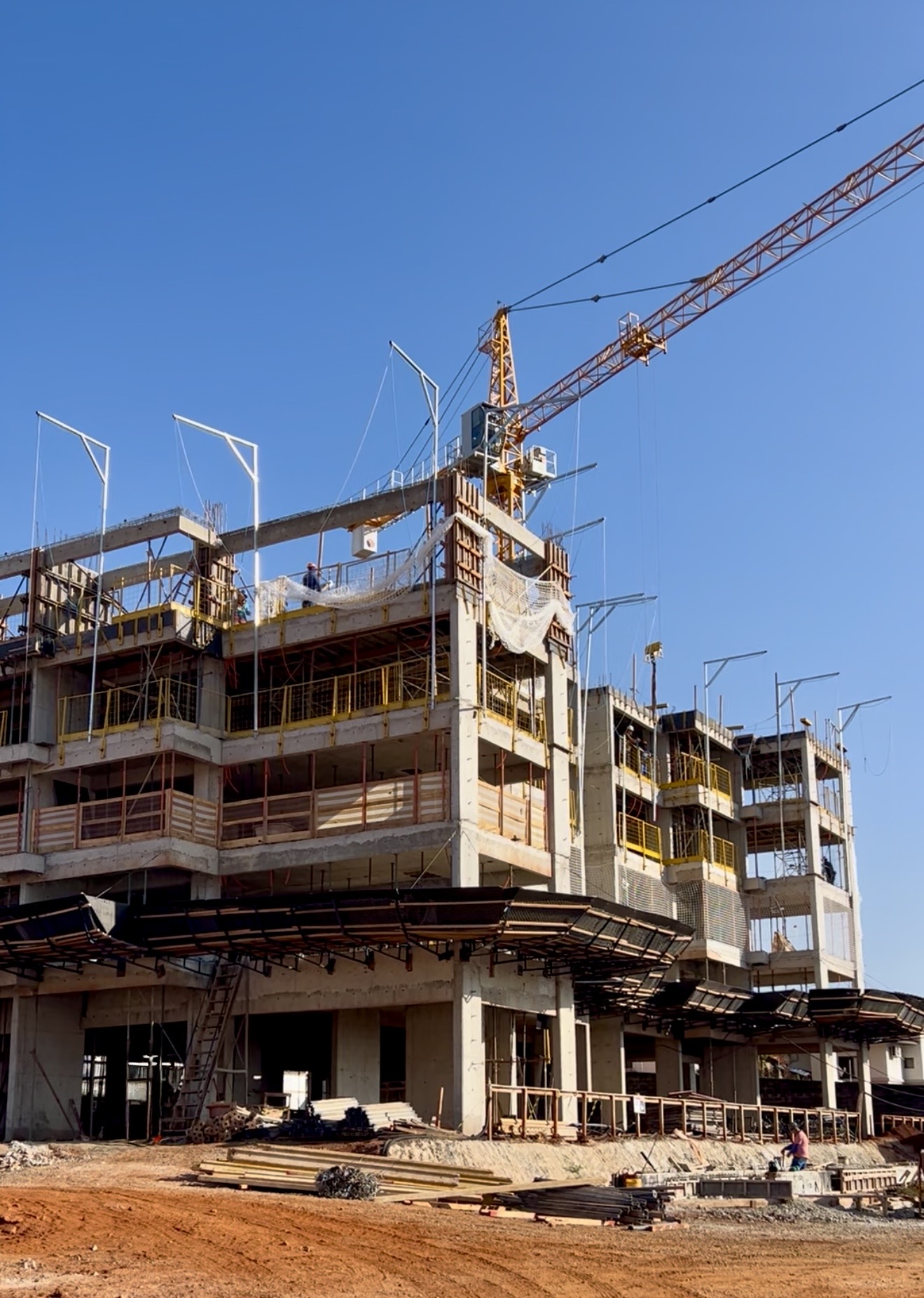 Estrutura de edifício em construção com guindaste e céu azul