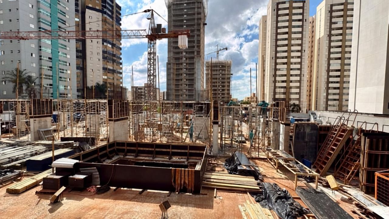 Canteiro de obra com formas, pilares e trabalhadores