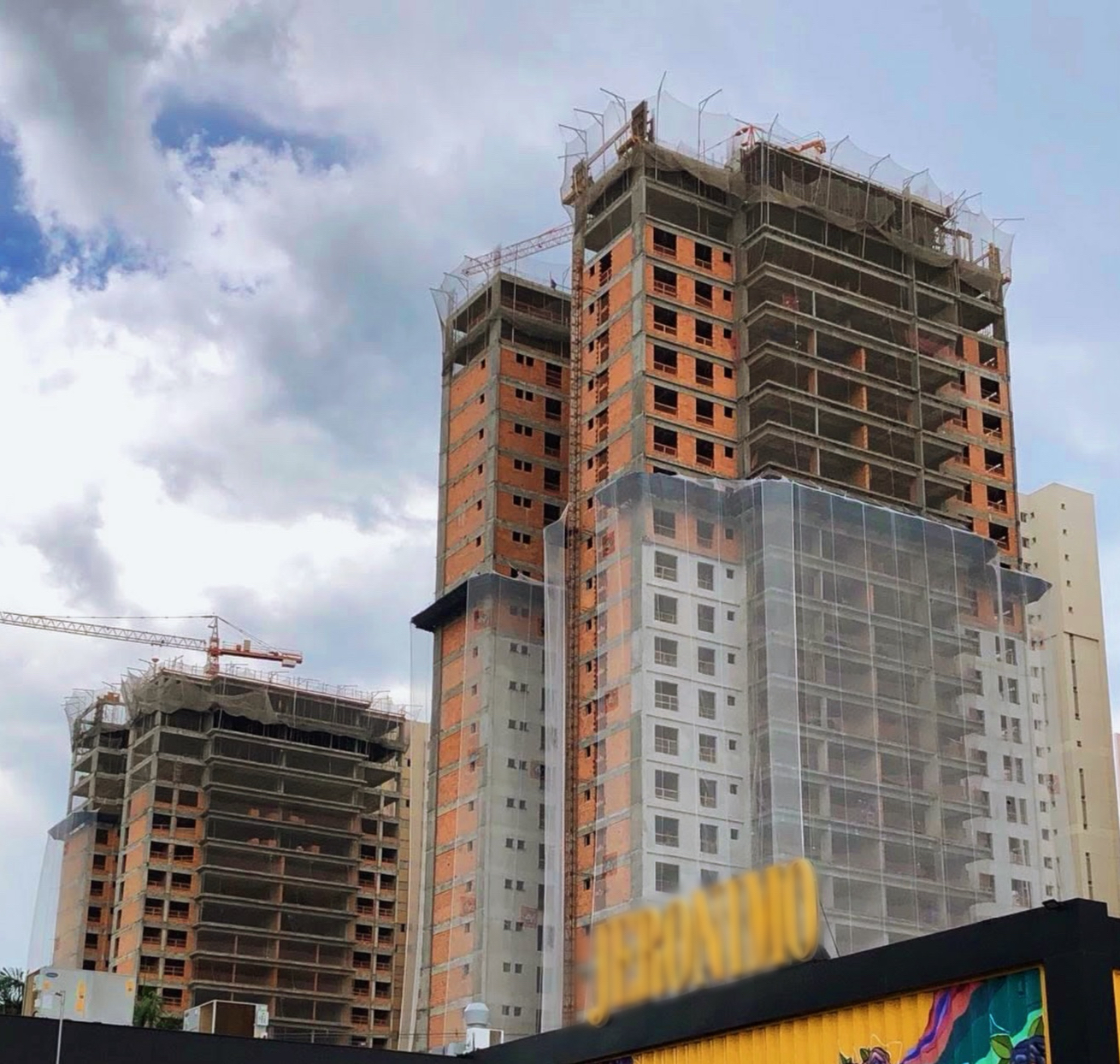 Torres em construção com estrutura de concreto e grua